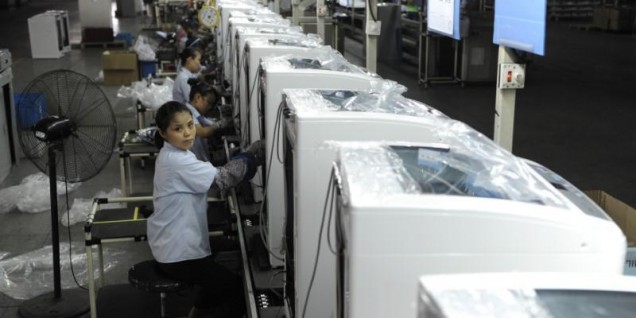 Employees assemble washing machines on the production line inside a factory of Hefei Rongshida Sanyo Electric in Hefei